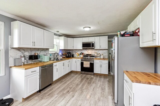 330 Union Camp Rd, Lafayette, TN 37083 - kitchen with wooden counters, stainless steel appliances, ornamental molding, decorative backsplash, and light wood finished floors