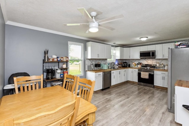 330 Union Camp Rd, Lafayette, TN 37083 - kitchen with stainless steel appliances, crown molding, white cabinets, a textured ceiling, and tasteful backsplash