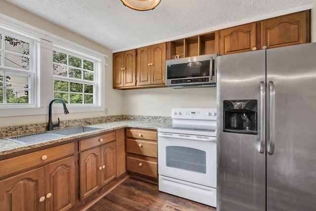 3328 Church St, Burns, TN 37029 - kitchen featuring appliances with stainless steel finishes, brown cabinets, dark wood-type flooring, a textured ceiling, and light stone counters