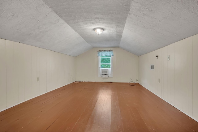 3328 Church St, Burns, TN 37029 - bonus room with wood-type flooring, cooling unit, lofted ceiling, and a textured ceiling