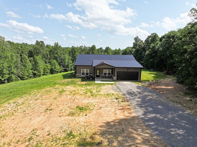 196 Deer Haven Rd, Indian Mound, TN 37079 - view of front of property featuring an attached garage, a metal roof, driveway, and a wooded view