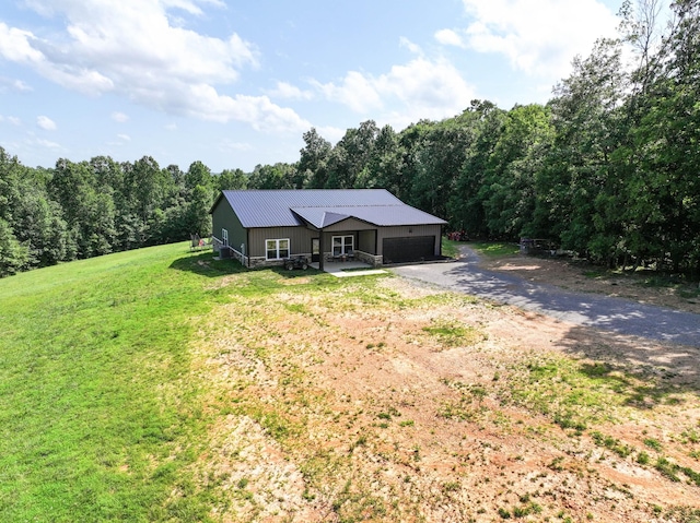196 Deer Haven Rd, Indian Mound, TN 37079 - view of front of property with driveway, an attached garage, a metal roof, a front yard, and a forest view