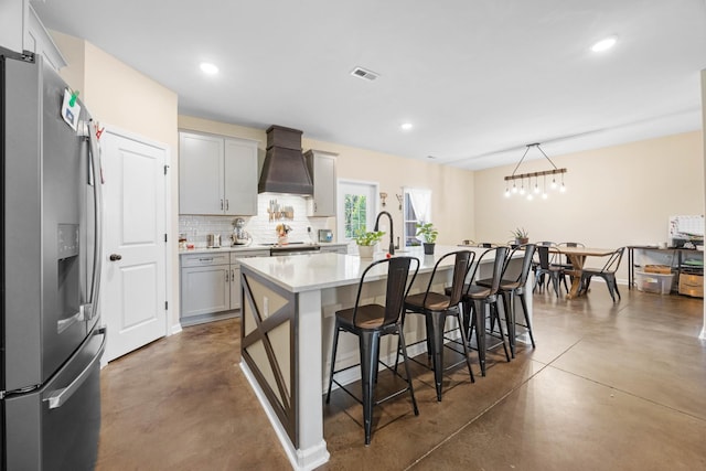 196 Deer Haven Rd, Indian Mound, TN 37079 - kitchen featuring stainless steel fridge, custom range hood, finished concrete floors, a kitchen breakfast bar, and tasteful backsplash
