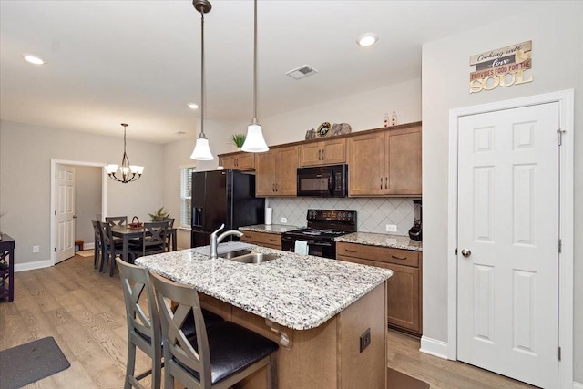 433 Longstone Rd, Gallatin, TN 37066 - kitchen featuring black appliances, backsplash, a center island with sink, light wood-type flooring, and brown cabinets