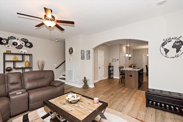 433 Longstone Rd, Gallatin, TN 37066 - living room featuring arched walkways, ceiling fan, light wood-style flooring, and stairway
