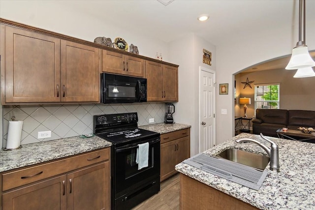 433 Longstone Rd, Gallatin, TN 37066 - kitchen with black appliances, tasteful backsplash, arched walkways, open floor plan, and light stone counters