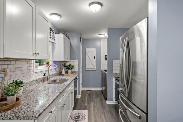 516 Cedarcrest Dr, Chapmansboro, TN 37035 - kitchen with appliances with stainless steel finishes, dark wood-type flooring, backsplash, white cabinets, and light stone countertops