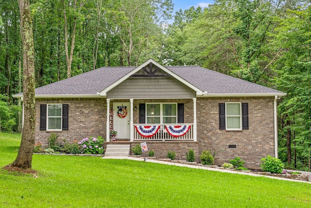 516 Cedarcrest Dr, Chapmansboro, TN 37035 - view of front of house featuring covered porch, a front yard, brick siding, and roof with shingles