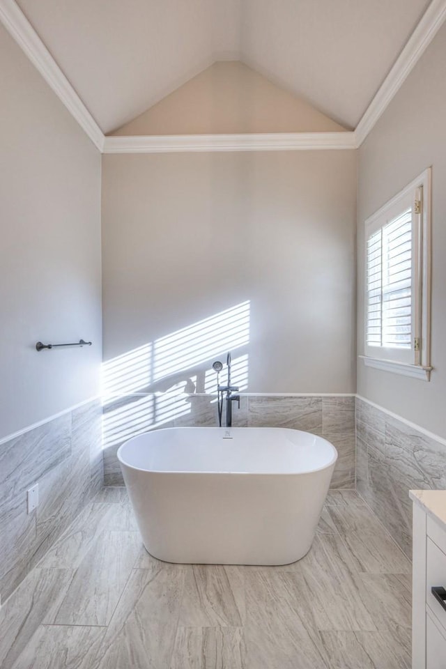 265 Stanley Park Ln, Franklin, TN 37069 - bathroom with tile walls, a freestanding tub, vaulted ceiling, vanity, and wainscoting