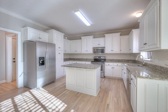 265 Stanley Park Ln, Franklin, TN 37069 - kitchen featuring appliances with stainless steel finishes, light wood finished floors, white cabinetry, a center island, and light stone counters