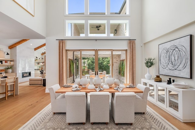 3005 Littlebury Park Dr, Thompsons Station, TN 37179 - dining space with a high ceiling, healthy amount of natural light, light wood-style floors, a tile fireplace, and beamed ceiling