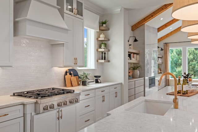 3005 Littlebury Park Dr, Thompsons Station, TN 37179 - kitchen featuring stainless steel gas cooktop, premium range hood, open shelves, backsplash, and beamed ceiling