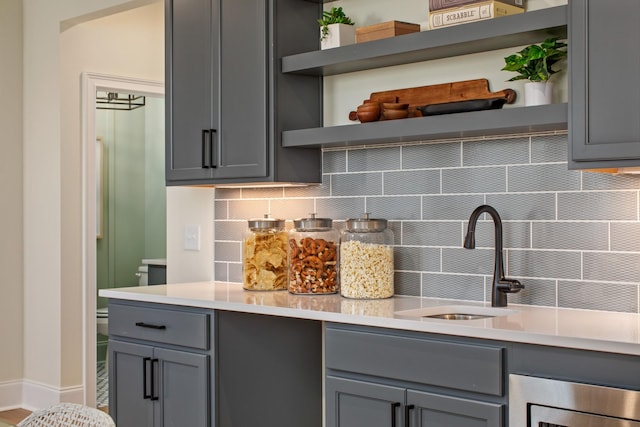 3005 Littlebury Park Dr, Thompsons Station, TN 37179 - kitchen with open shelves, gray cabinetry, backsplash, and light countertops