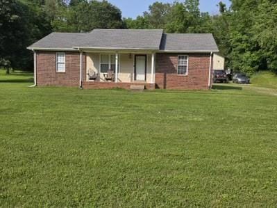 1726 Old Clarksville Pike, Chapmansboro, TN 37035 - ranch-style house with a porch, a front lawn, and brick siding