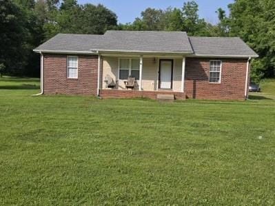 1726 Old Clarksville Pike, Chapmansboro, TN 37035 - ranch-style house with a porch, a front lawn, brick siding, and view of scattered trees