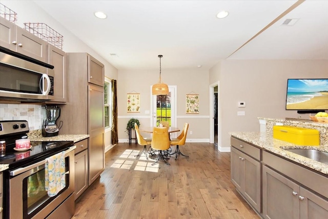 3028 Honeysuckle Dr, Spring Hill, TN 37174 - kitchen featuring appliances with stainless steel finishes, backsplash, light wood-style floors, recessed lighting, and pendant lighting
