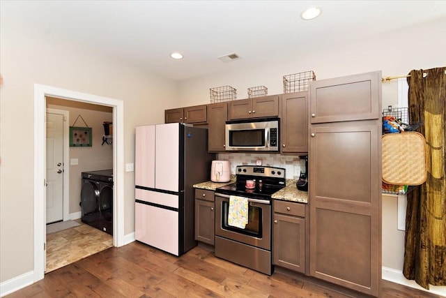 3028 Honeysuckle Dr, Spring Hill, TN 37174 - kitchen featuring appliances with stainless steel finishes, washer and dryer, dark wood finished floors, tasteful backsplash, and recessed lighting