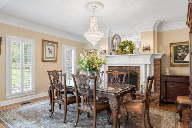 2208 Chadwick Ct, Mount Juliet, TN 37122 - dining room featuring wood finished floors, a chandelier, crown molding, and a brick fireplace