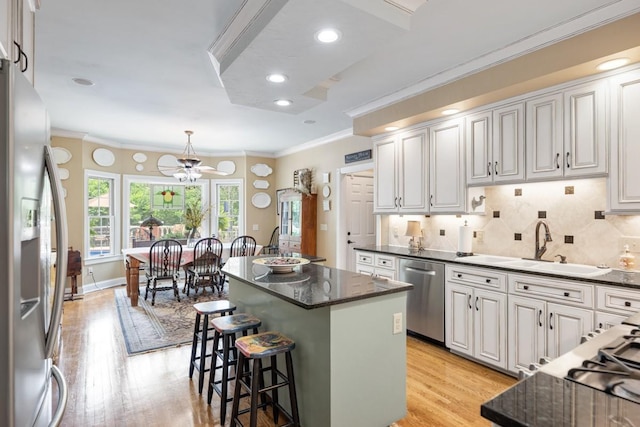 2208 Chadwick Ct, Mount Juliet, TN 37122 - kitchen with stainless steel appliances, light wood-style flooring, ornamental molding, a center island, and a breakfast bar area