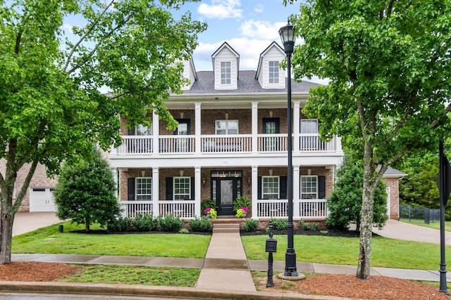 368 Pennystone Cir, Franklin, TN 37067 - view of front of house with a balcony, brick siding, a porch, and a front lawn