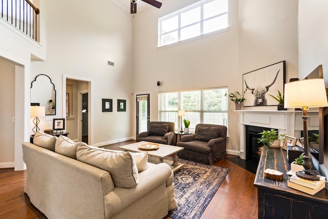 368 Pennystone Cir, Franklin, TN 37067 - living area with a high ceiling, a ceiling fan, dark wood-style floors, a fireplace with flush hearth, and plenty of natural light