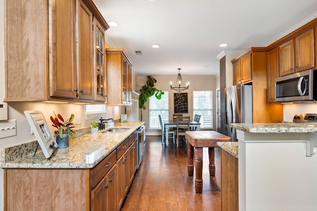 368 Pennystone Cir, Franklin, TN 37067 - kitchen featuring stainless steel appliances, brown cabinets, crown molding, dark wood finished floors, and light stone countertops