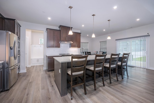 1401 Kennebec Dr, Smyrna, TN 37167 - kitchen with stainless steel fridge, light wood-style flooring, under cabinet range hood, light countertops, and healthy amount of natural light