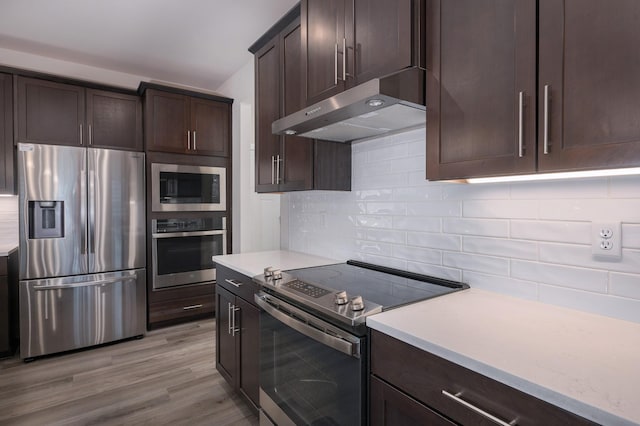1401 Kennebec Dr, Smyrna, TN 37167 - kitchen with appliances with stainless steel finishes, under cabinet range hood, dark brown cabinets, and light countertops