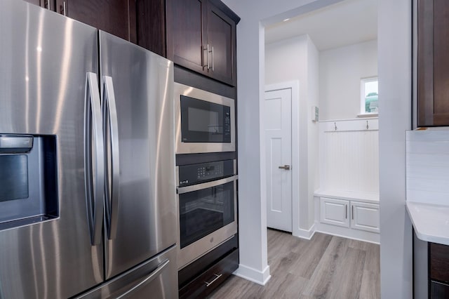 1401 Kennebec Dr, Smyrna, TN 37167 - kitchen featuring appliances with stainless steel finishes, dark brown cabinetry, light wood-style floors, and light countertops