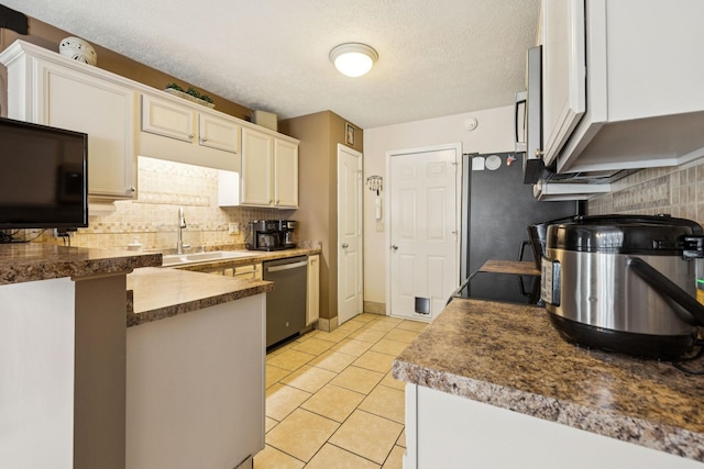 1652 Saint Andrews Dr, Murfreesboro, TN 37128 - kitchen featuring stainless steel dishwasher, backsplash, white cabinets, light tile patterned floors, and a peninsula