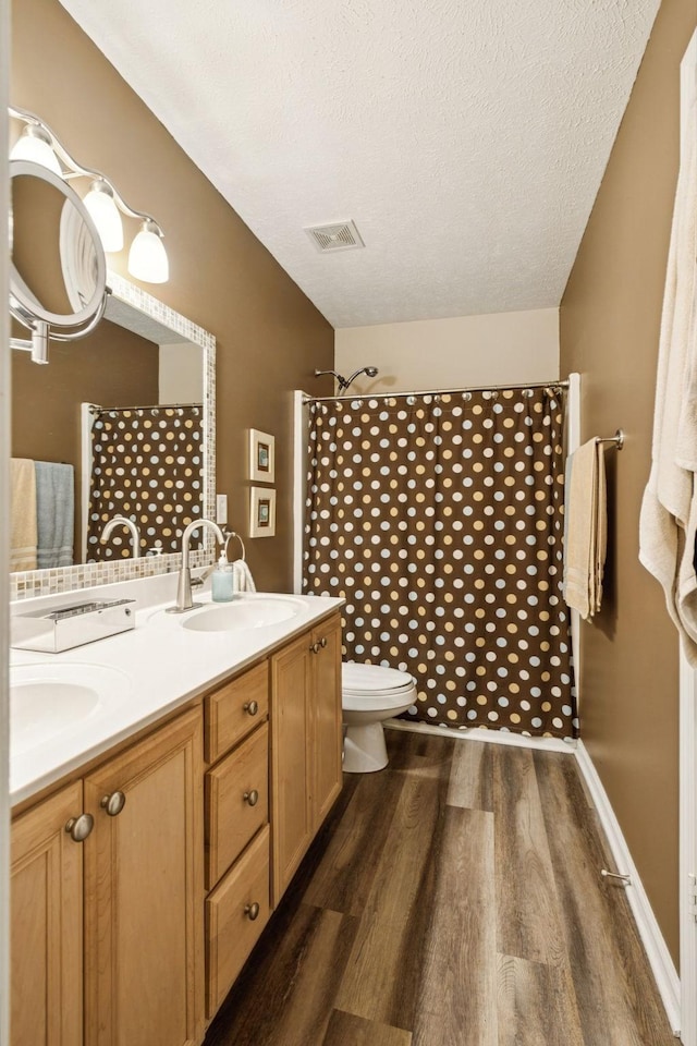 1652 Saint Andrews Dr, Murfreesboro, TN 37128 - bathroom with wood finished floors, double vanity, a shower with shower curtain, and a textured ceiling