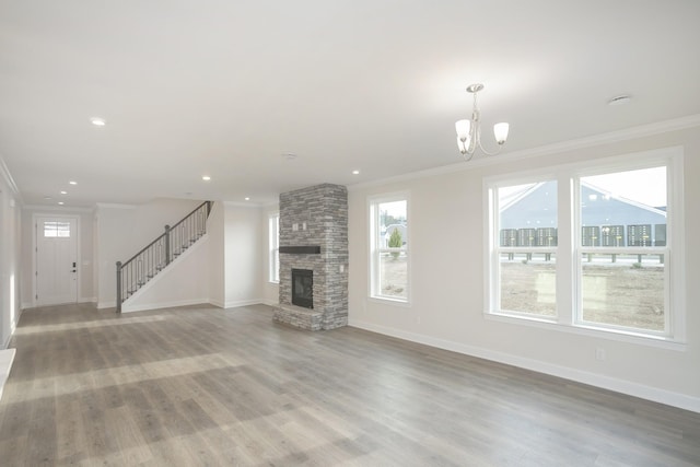 3294 Camden Ct, Mount Juliet, TN 37122 - unfurnished living room with crown molding, healthy amount of natural light, a chandelier, stairs, and a fireplace