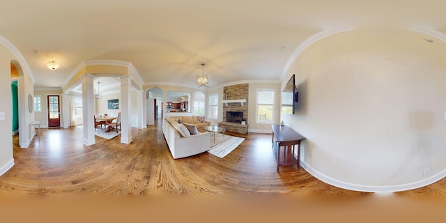 166 Azalea Ln, Franklin, TN 37064 - living room with ornate columns, arched walkways, wood finished floors, a fireplace, and ornamental molding