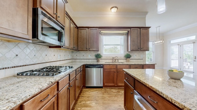 166 Azalea Ln, Franklin, TN 37064 - kitchen with appliances with stainless steel finishes, ornamental molding, light wood-type flooring, light stone countertops, and tasteful backsplash