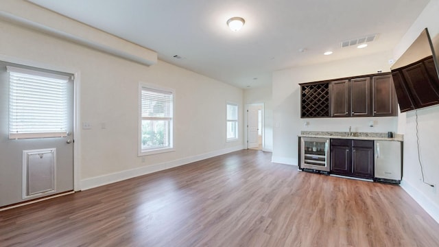 166 Azalea Ln, Franklin, TN 37064 - unfurnished living room featuring beverage cooler, bar with sink, and light wood-type flooring