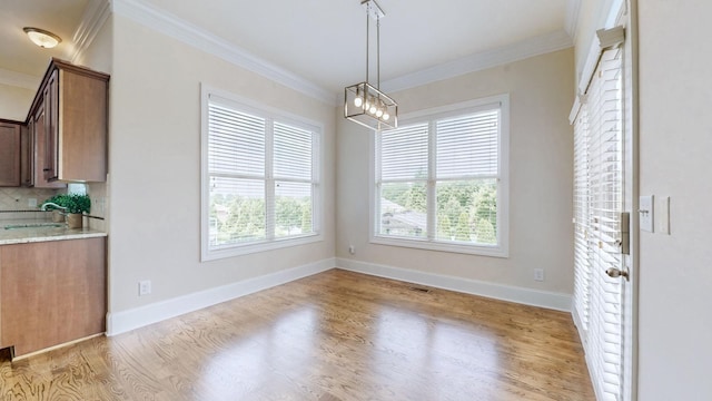 166 Azalea Ln, Franklin, TN 37064 - unfurnished dining area featuring crown molding, light wood finished floors, and a chandelier