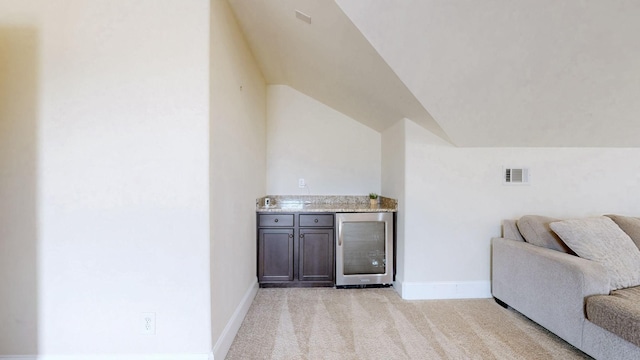 166 Azalea Ln, Franklin, TN 37064 - living room featuring beverage cooler, bar, light carpet, and lofted ceiling