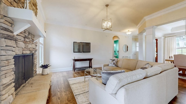 166 Azalea Ln, Franklin, TN 37064 - living area featuring ornamental molding, wood finished floors, a chandelier, a stone fireplace, and arched walkways