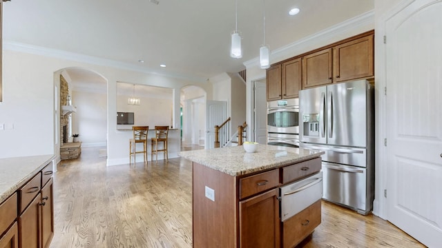 166 Azalea Ln, Franklin, TN 37064 - kitchen featuring appliances with stainless steel finishes, arched walkways, a warming drawer, brown cabinets, and crown molding