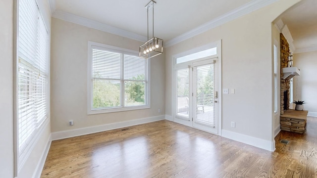 166 Azalea Ln, Franklin, TN 37064 - unfurnished dining area with wood finished floors, ornamental molding, arched walkways, a fireplace, and a chandelier