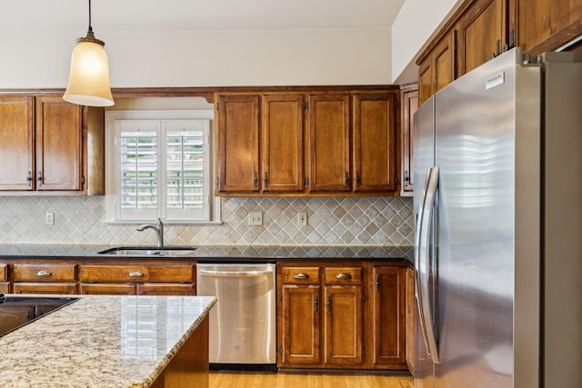 410 Ridge View Ct, Franklin, TN 37067 - kitchen with appliances with stainless steel finishes, dark stone countertops, decorative backsplash, pendant lighting, and brown cabinets