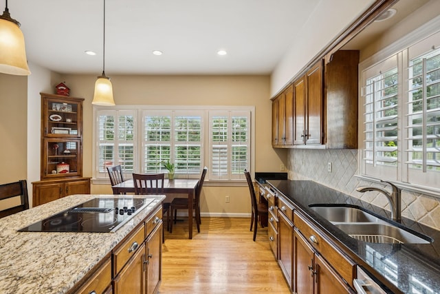 410 Ridge View Ct, Franklin, TN 37067 - kitchen with black electric stovetop, light wood finished floors, hanging light fixtures, recessed lighting, and tasteful backsplash