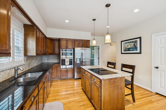 410 Ridge View Ct, Franklin, TN 37067 - kitchen featuring appliances with stainless steel finishes, a breakfast bar area, decorative backsplash, light wood-style flooring, and a kitchen island