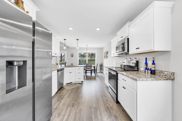541 Macy Lynn Dr, Clarksville, TN 37042 - kitchen featuring stainless steel appliances, a peninsula, light wood finished floors, white cabinetry, and recessed lighting