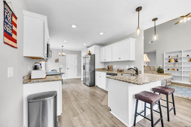 541 Macy Lynn Dr, Clarksville, TN 37042 - kitchen featuring stainless steel appliances, light wood-style flooring, white cabinetry, a peninsula, and light stone counters