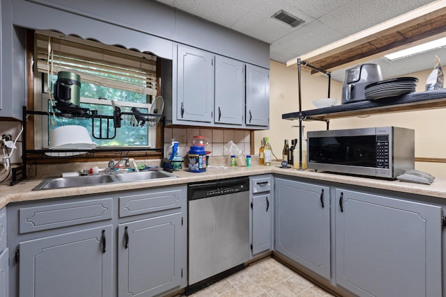 1325 City View St SE, Cleveland, TN 37311 - kitchen with appliances with stainless steel finishes, gray cabinetry, a drop ceiling, light countertops, and decorative backsplash