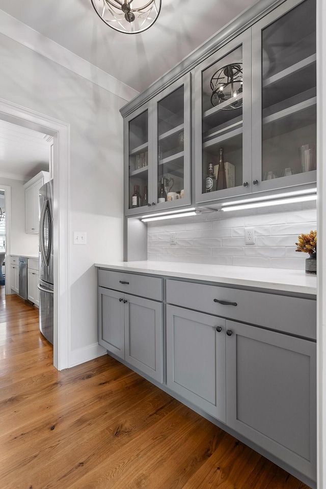 2305 Weeping Willow Dr, Ooltewah, TN 37363 - bar with stainless steel appliances, decorative backsplash, and wood finished floors