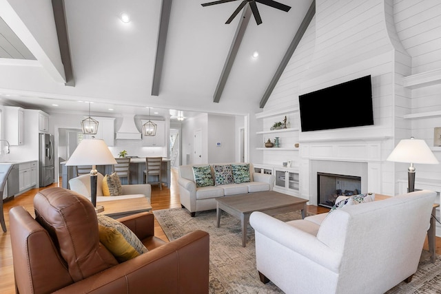 2305 Weeping Willow Dr, Ooltewah, TN 37363 - living area with a ceiling fan, a fireplace, beamed ceiling, light wood-type flooring, and high vaulted ceiling