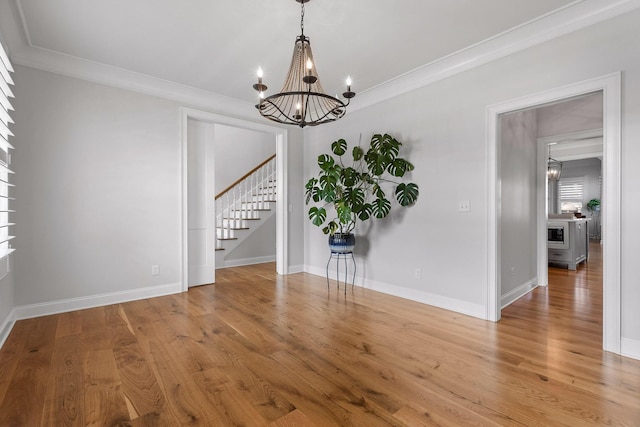 2305 Weeping Willow Dr, Ooltewah, TN 37363 - spare room featuring stairway, a chandelier, crown molding, and light wood-type flooring