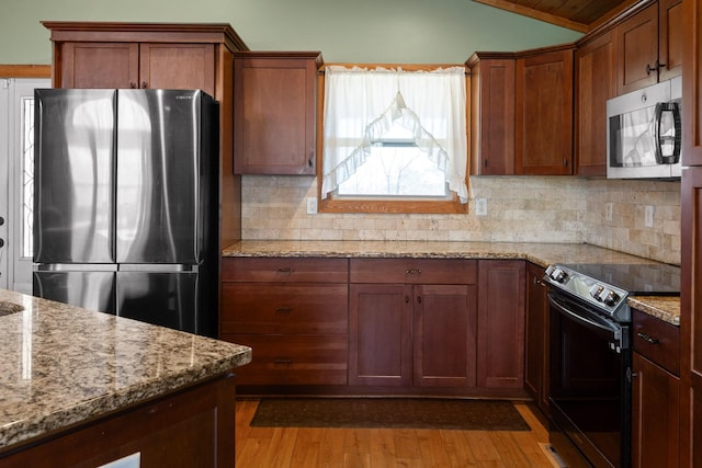 1080 Harp Switch Rd, Chickamauga, GA 30707 - kitchen with appliances with stainless steel finishes, vaulted ceiling, light wood-style flooring, decorative backsplash, and light stone counters